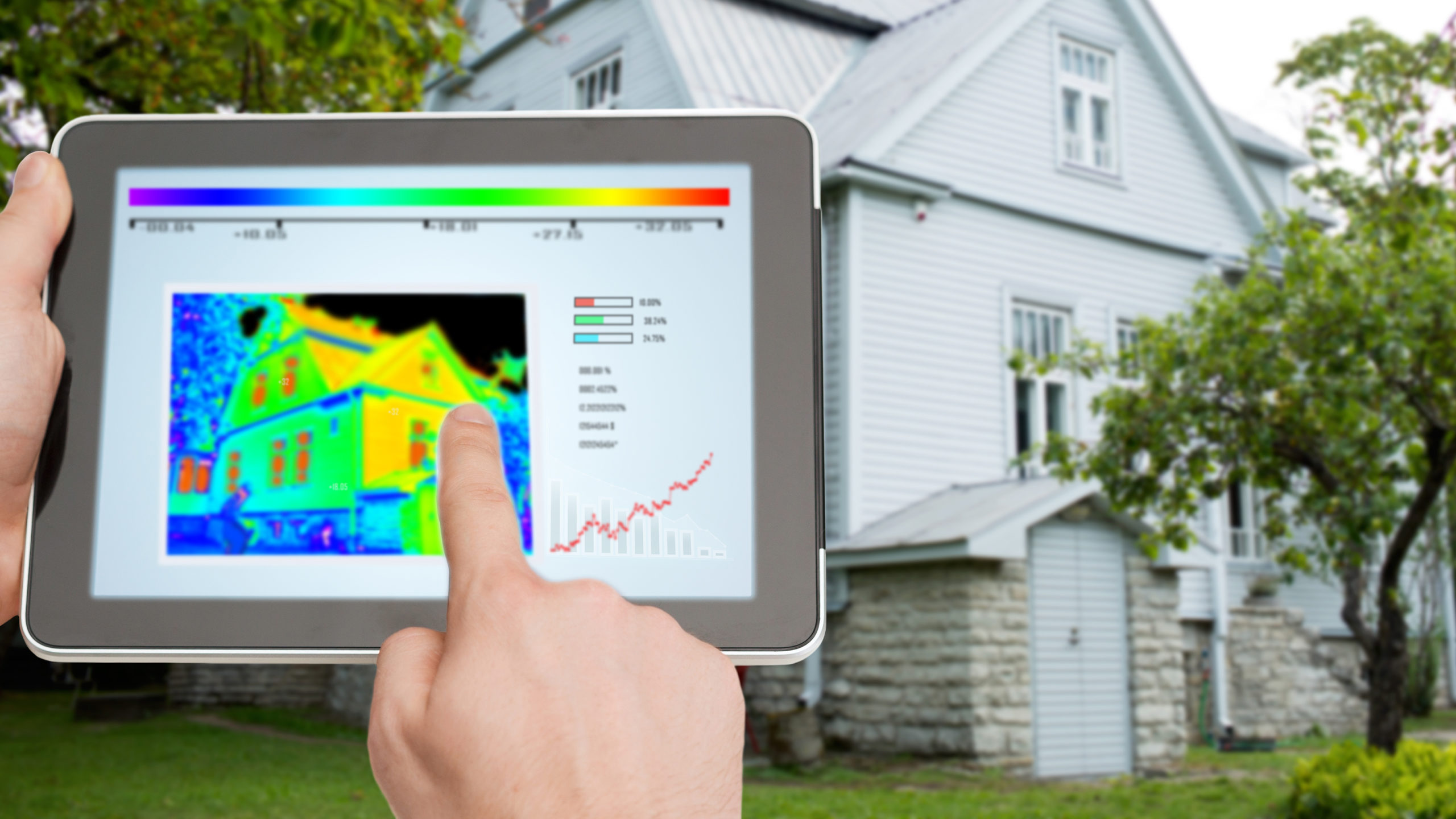 Tablet mit Wärmebild vor einem Haus